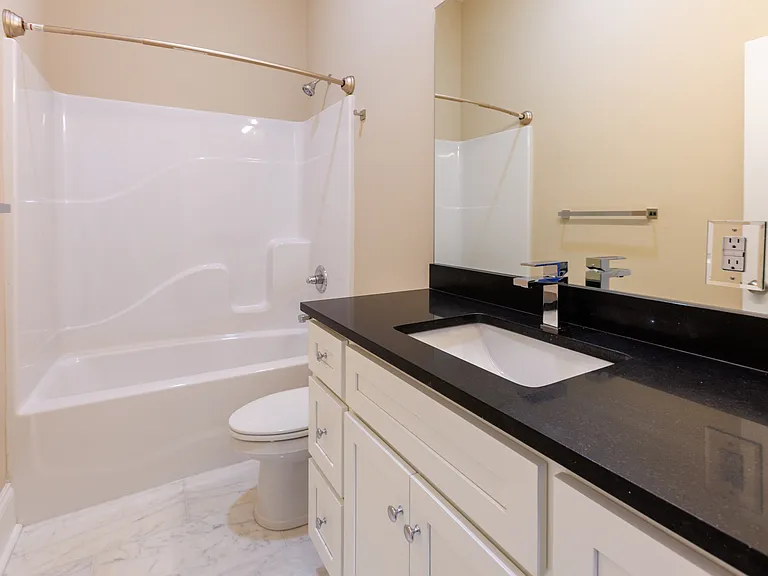 Brand-new bathroom featuring modern fixtures, a spacious vanity, and bathtub/shower combo.