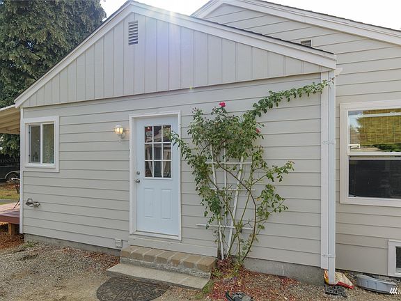 East side view of the home with doorway leading to the kitchen.>
