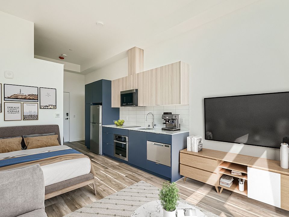 Enjoy relaxation in this cozy bedroom at Anker Ballard, featuring a comfortable bed, TV, and stylish decor that creates a welcoming atmosphere.