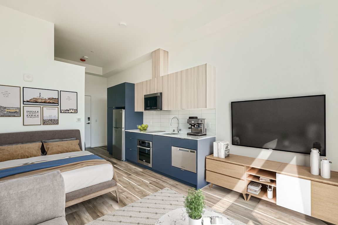 Enjoy relaxation in this cozy bedroom at Anker Ballard, featuring a comfortable bed, TV, and stylish decor that creates a welcoming atmosphere.