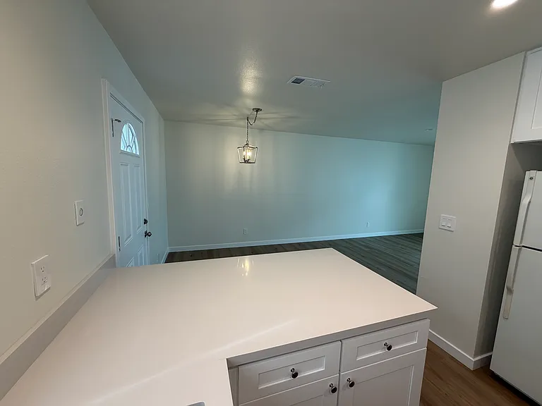 Kitchen looking towards dining area with hanging light fixture