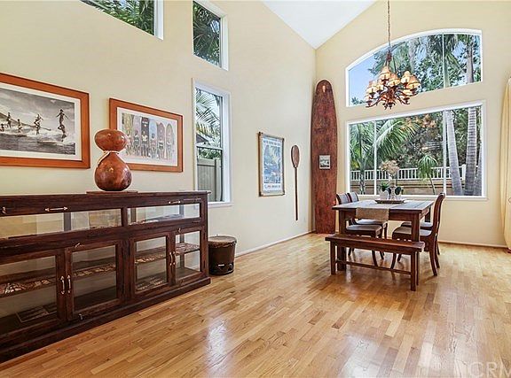 Formal Living Room & Dining Room with Hardwood Flooring and High Vaulted Ceiling.