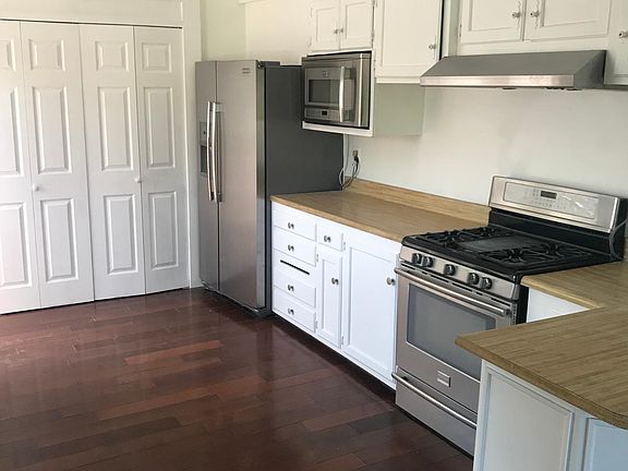 Kitchen with refrigeratoirtor and stove top.