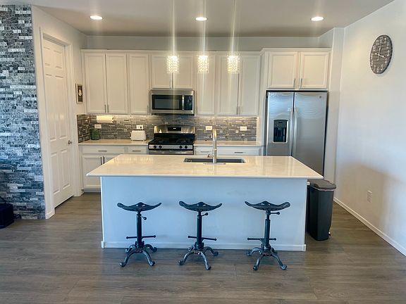 Kitchen with granite countertops, stainless appliances, walk-in pantry and island.