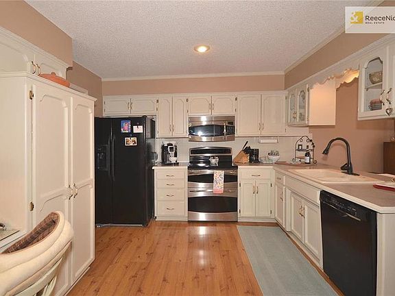 Updated kitchen with painted cabinets, wood floors and built-in pantry