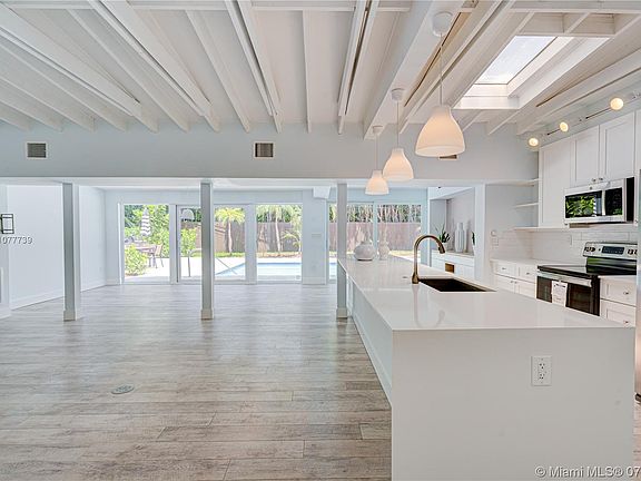 Open floor plan with wood beam ceiling