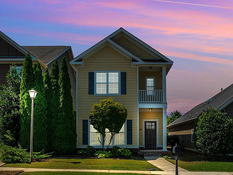 The house is well-lit at night with nearby street lighting