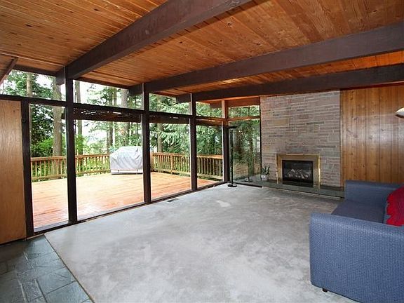Earth tones thought out, Comfortable living room with gas fireplace over looking the entertainment size deck. Hardwood under carpet. Classic slate entry. Burrows built home in 1961.