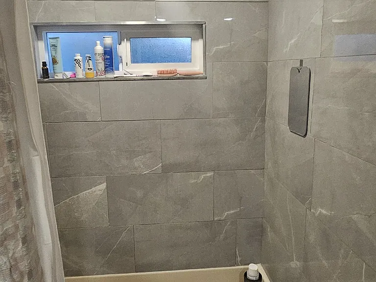bathroom update after with new tile, light, and window
