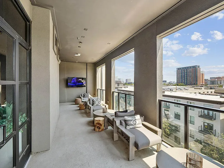 Sky deck with lounge chairs, coffee tables, and TV.