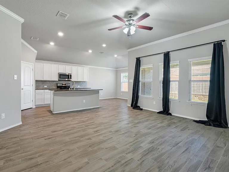 Open-concept living area with wood-finish flooring, recessed lighting, and a ceiling fan