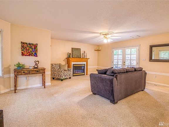Living room w/ fireplace and french doors to covered back patio.