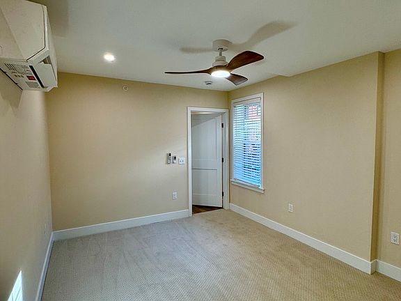 Large serene bedroom with stylish ceiling fan/light