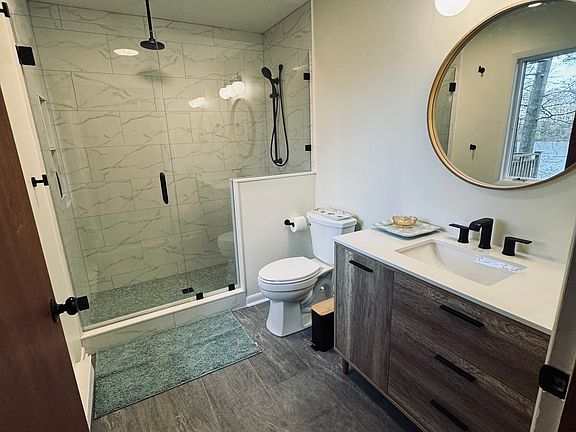 Recently updated master bathroom with rain shower and hand held shower head. Additional towel holder bars are behind door.