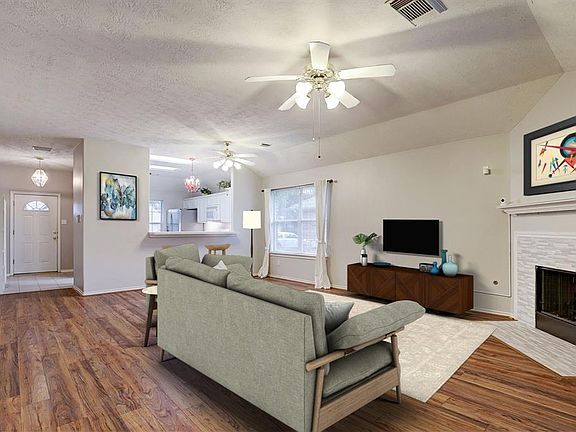 Nice size living area with a fireplace. Virtually staged to provide an idea of furniture placement.