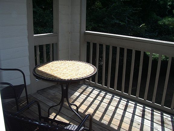 Covered Porch with small table and two chairs. Facing out to the woods. Storage closet is off of the porch.