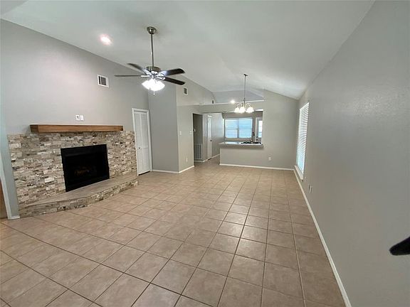 Spacious living area featuring vaulted ceilings and neutral wall tones