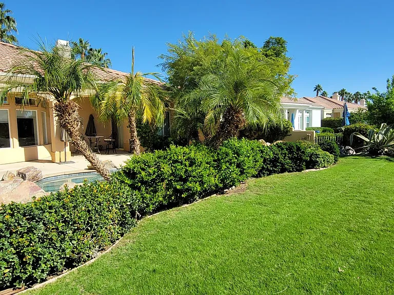 Green grass area on the backside of the pool, view of the golf course and beautiful mountains.