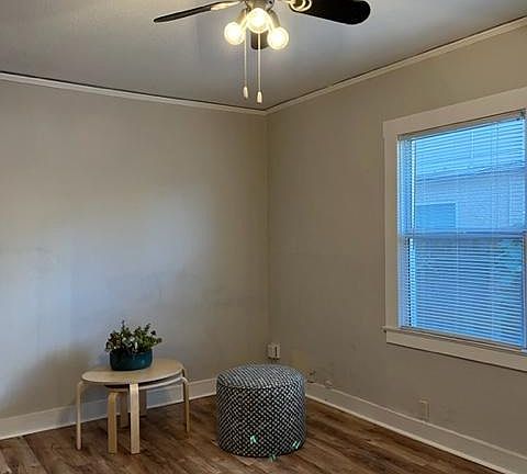 Living space opens to another room that could be used for dining or an office. Wood laminate flooring, ceiling fan, two tone paint, picture molding.