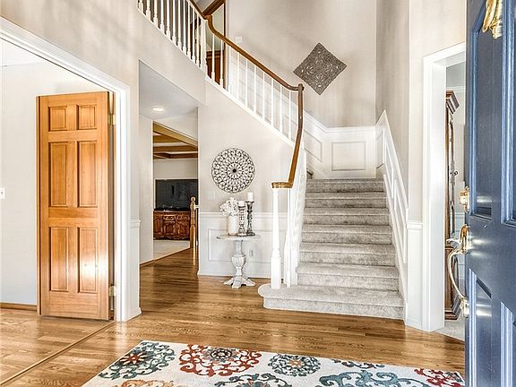 Dramatic 2 story entry with hardwoods and spindle staircase. Room to the left is the office/den with double doors. 