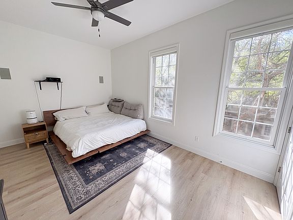 Large primary suite with ceiling fans, room darkening shades, en-suite bath, good sized closet, new hardwood floors