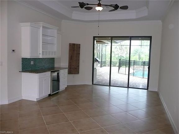 Living room with Tray Ceiling, Dry Bar, Crown Molding and Tile flooring