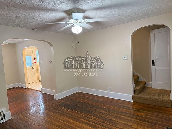 view from living room corner of the stairway and kitchen entrance.