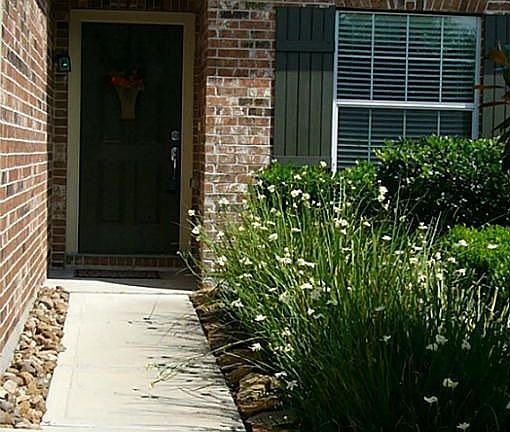 The front walk is landscaped and well maintained.The fragrant Iris plants are in bloom...come see this home today!