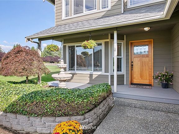 Welcoming entryway with gorgeous landscaping and fountain in front of the covered porch. 