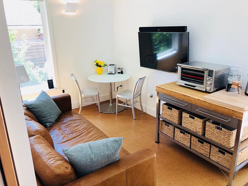 Dining table and chairs, leather sofa, wall-mounted Smart TV with swivel bracket, butcher block topped island with lots of storage.
