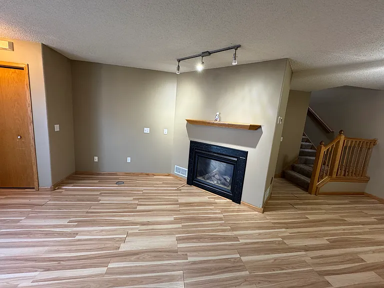 Living full view with gas fireplace, entry closet and stairs
