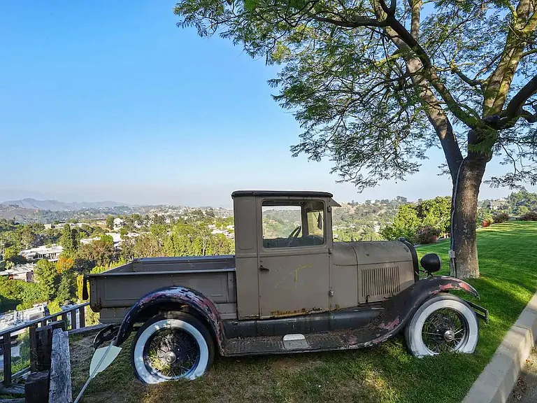 Discover vintage touches in the garden, providing a charming space under a big tree for shade and a lush green lawn.