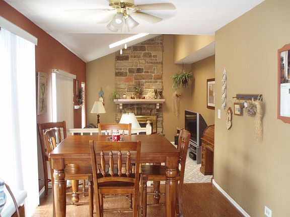Family Room with 2 skylights, sliding door to backyard, and stone fireplace