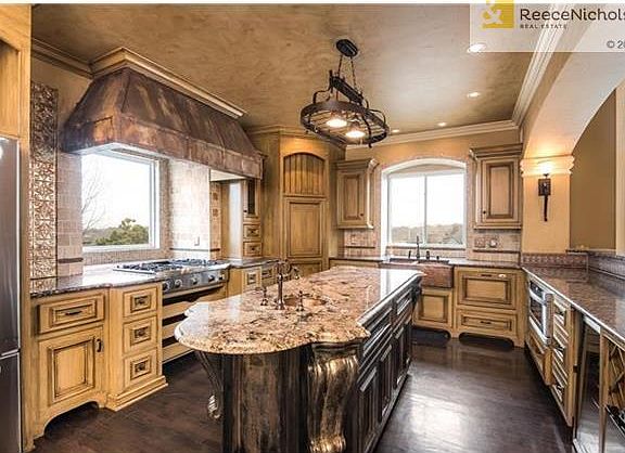 Chef's kitchen complete with granite island, copper farm sink, bar refrigerator.
