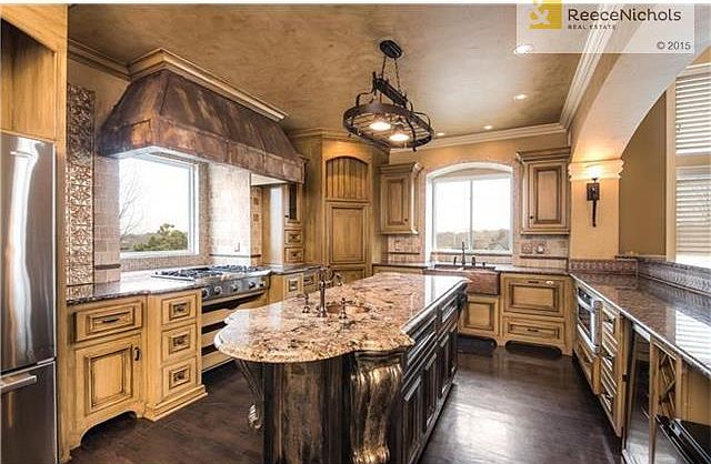 Chef's kitchen complete with granite island, copper farm sink, bar refrigerator.