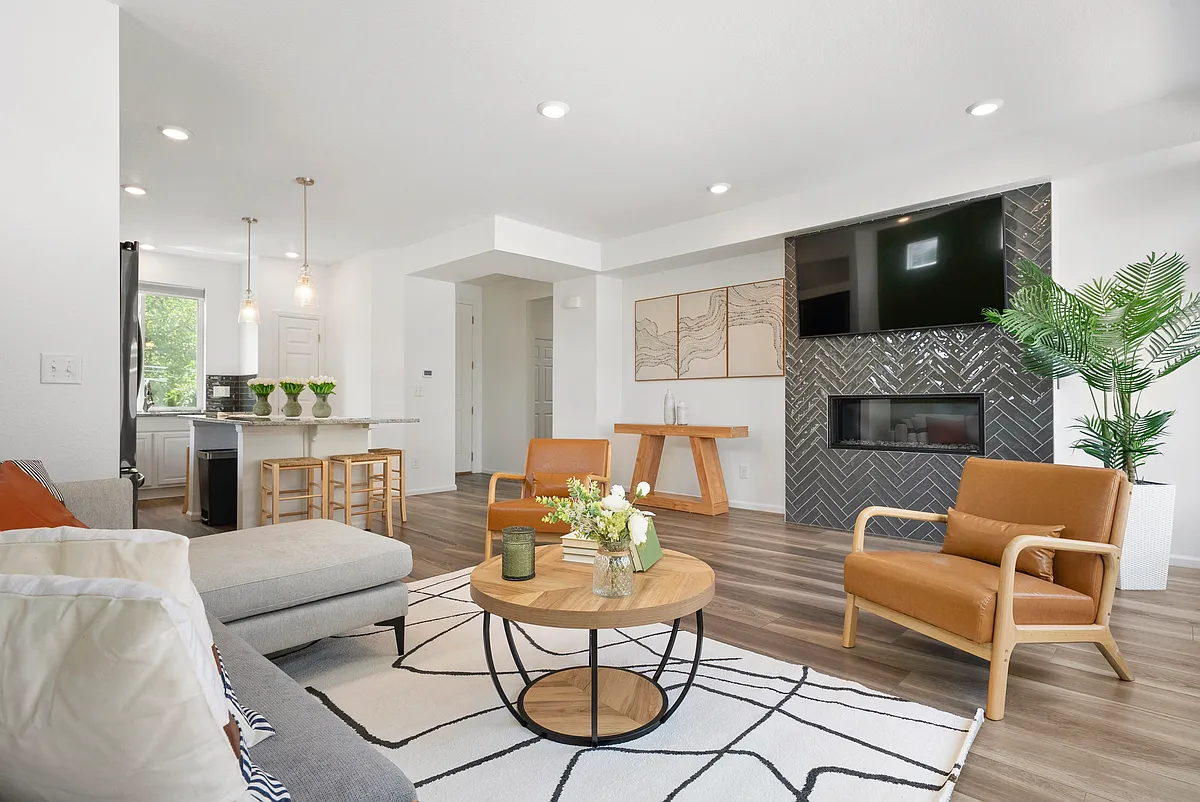 Cozy, stylish living room with fireplace, modern kitchen, and natural light. Comfortable seating and elegant decor create a relaxing atmosphere. Perfect for remote work or unwinding. Book your peaceful, modern stay near parks and dining! - 10152 Yampa Ct