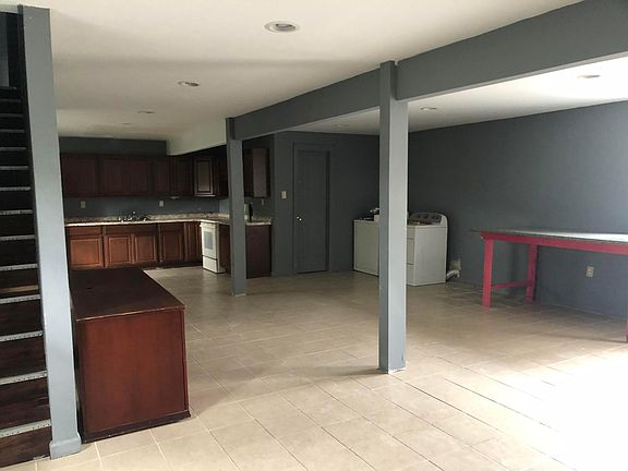 different angle of living room and kitchen area, door leads to full bathroom