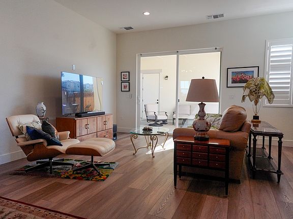 Downstairs living area, with a 65" television and several comfortable places included. Connected to the kitchen and dining area. The California room is accessible through the sliding doors.