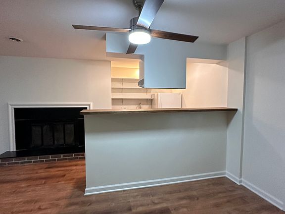 The galley kitchen, with its bar. Fireplace to the left. Note ceiling fans.