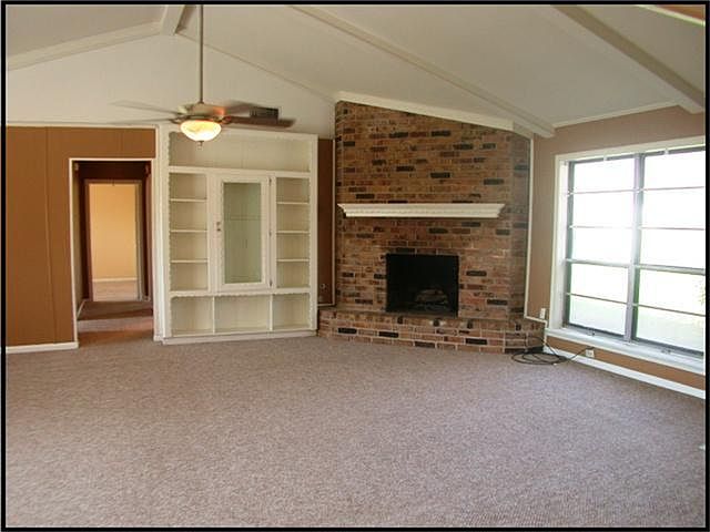 FAMILY ROOM WITH WOOD BURNING FIREPLACE, VAULTED CEILINGS, RECENT BERBER CARPET AND BUILT-INS.
