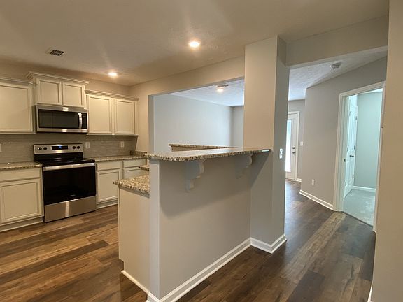 Awesome kitchen with granite, back-splash, stainless steel appliances and laminate flooring