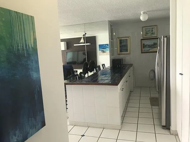 Entrance with kitchen front view, living room and balcony on the left, 2 bedrooms and bath rooms on the right.