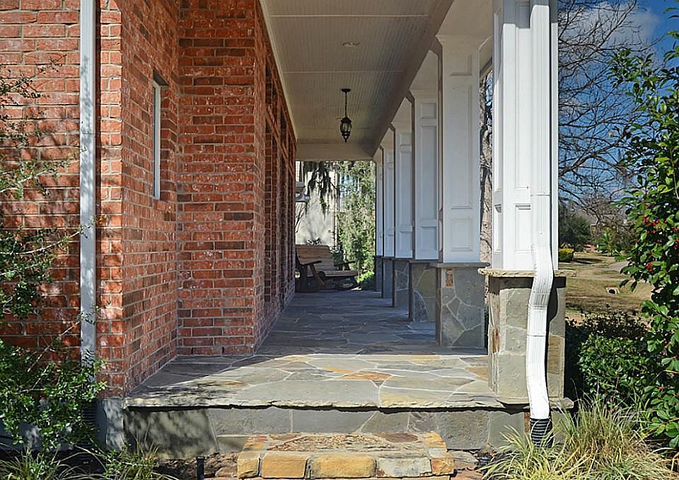 Flagstone, brick and a bead-board ceiling mix with remarkable views thru cased columns to provide an inviting spot to spend a leisurely afternoon watching friendly neighbors walk past.