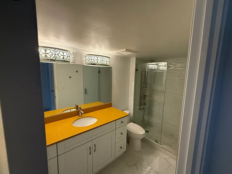 MASTER BATHROOM with limited-edition custom quartz countertop, large vanity mirror, dimmable designer lighting & step-in shower with spa massage jets