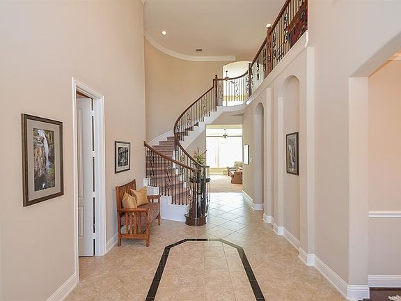 The wrought iron and glass double doors leave a lasting impression as you enter this impressive home.