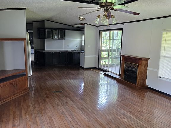 Great room area including kitchen, washer and dryer hookups, propane fireplace and living room including fan