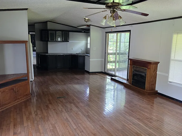 Great room area including kitchen, washer and dryer hookups, propane fireplace and living room including fan