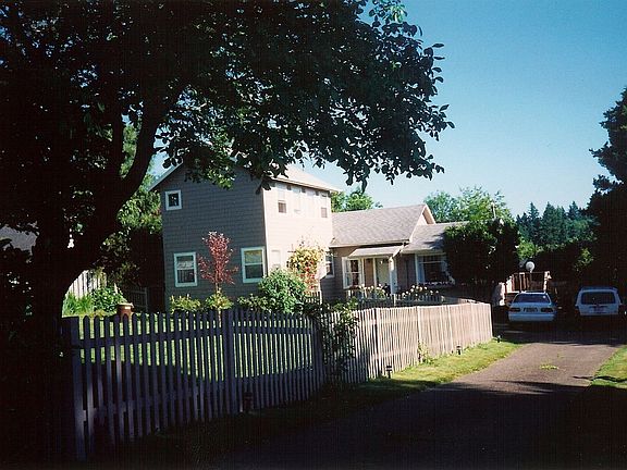 Street view. 2 mature walnut trees in yard.