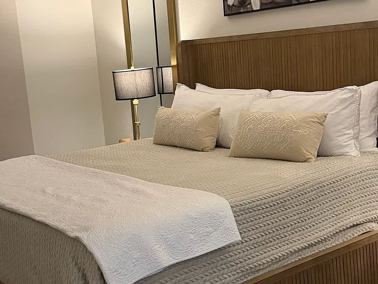 Master bedroom with plush linens. Both bedrooms have flat screen televisions.