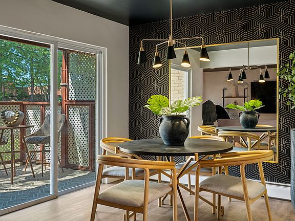 Beautiful dinning room with stunning wallpaper backdrop anchored by a large mirror which gives the room depth. The black ceiling and mid century style chandalier add a touch of elegance. Patio sliders lead out to your private patio area and outdoor grill.